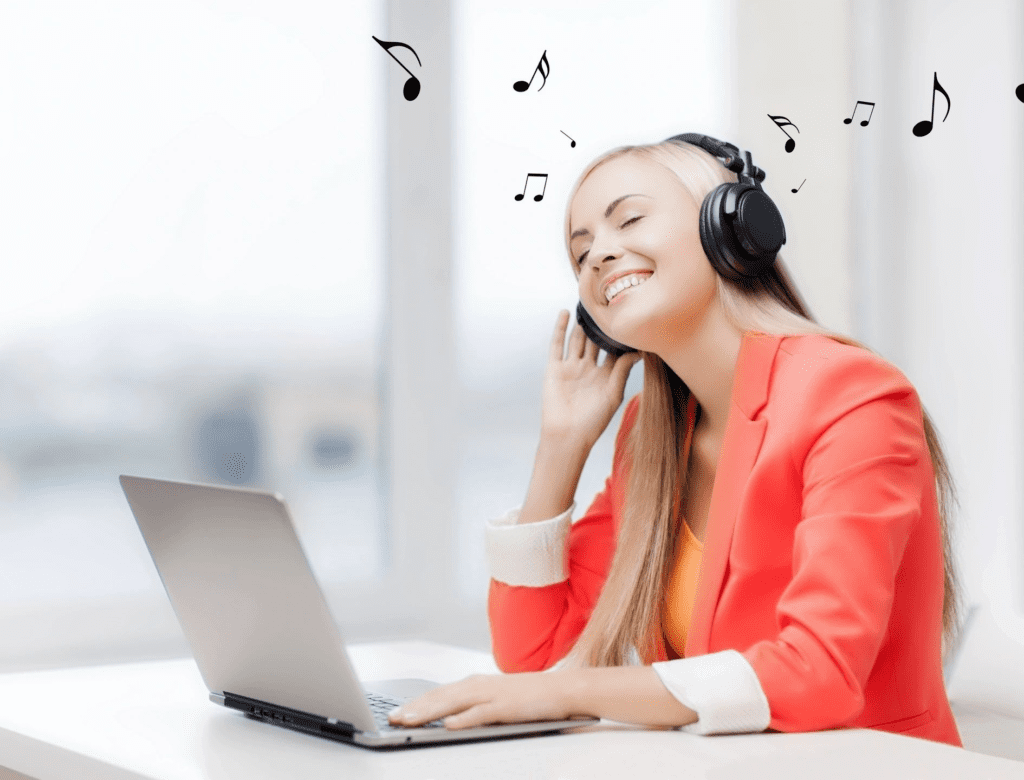 A woman with headphones on sitting at her laptop