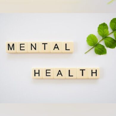 A white table with scrabble tiles that spell out mental health.